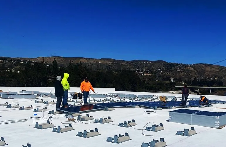 An employee working leading others on how to place our solar panels.