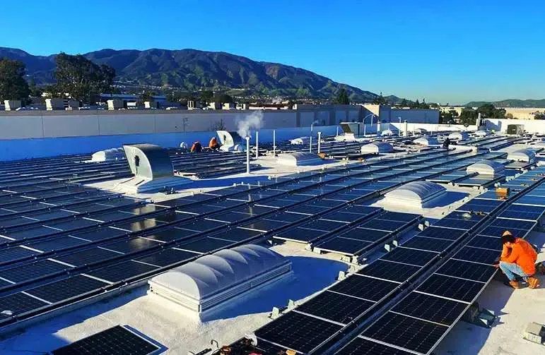 A company building with workers working on the solar panels.